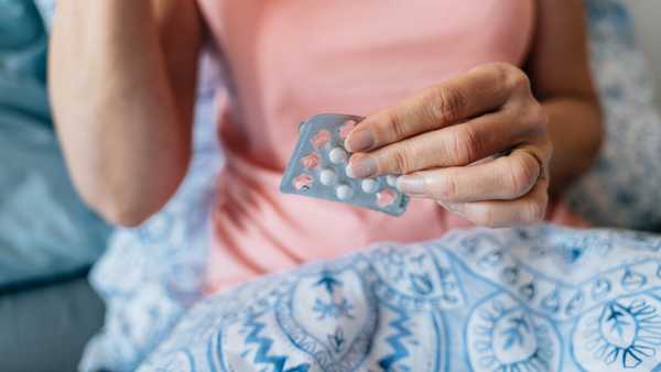 Close-up of woman hands with blister of pills. Hormone replacement therapy