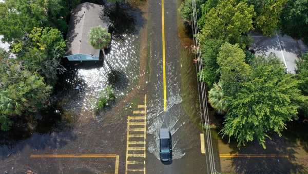 CRYSTAL RIVER, FLORIDA - AUGUST 30: In an aerial view, a vehicle drives through a flooded street after Hurricane Idalia passed offshore on August 30, 2023 in Crystal River, Florida. Hurricane Idalia hit the Big Bend area of Florida. (Photo by Joe Raedle/Getty Images)