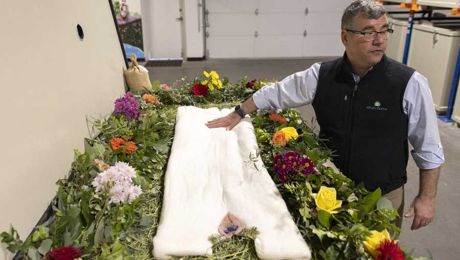 TOPSHOT - Return Home CEO Micah Truman shows a demonstration "vessel" for the deceased, decorated with flowers and compostable mementos on top of a bed of straw by Return Home, during a tour of the funeral home which specializes in human composting in Auburn, Washington on March 14, 2022. - Washington in 2019 became the first in the United States to make it a legal alternative to cremation. (Photo by Jason Redmond / AFP) (Photo by JASON REDMOND/AFP via Getty Images)