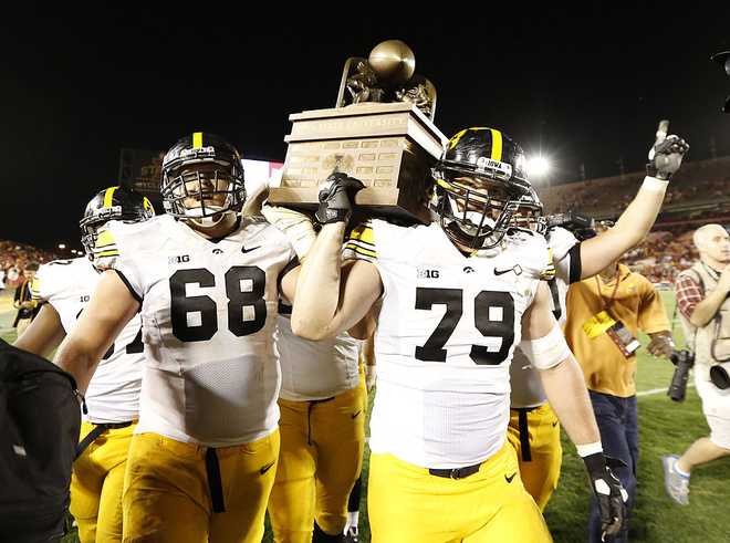 AMES,&#x20;IA&#x20;&#x00D0;&#x20;SEPTEMBER&#x20;14&#x3A;&#x20;Offensive&#x20;linesman&#x20;Brandon&#x20;Scherff&#x20;&#x23;68&#x20;and&#x20;his&#x20;teammate&#x20;defensive&#x20;lineman&#x20;Dominic&#x20;Alvis&#x20;&#x23;79&#x20;of&#x20;the&#x20;Iowa&#x20;Hawkeyes&#x20;celebrate&#x20;their&#x20;win&#x20;over&#x20;the&#x20;Iowa&#x20;State&#x20;Cyclones&#x20;27-21&#x20;by&#x20;carrying&#x20;the&#x20;Cy-Hawk&#x20;Trophy&#x20;to&#x20;their&#x20;fans&#x20;at&#x20;Jack&#x20;Trice&#x20;Stadium&#x20;on&#x20;September&#x20;14,&#x20;2013&#x20;in&#x20;Ames,&#x20;Iowa.&#x20;Iowa&#x20;defeated&#x20;Iowa&#x20;State&#x20;27-21.&#x20;&#x28;Photo&#x20;by&#x20;David&#x20;Purdy&#x2F;Getty&#x20;Images&#x29;