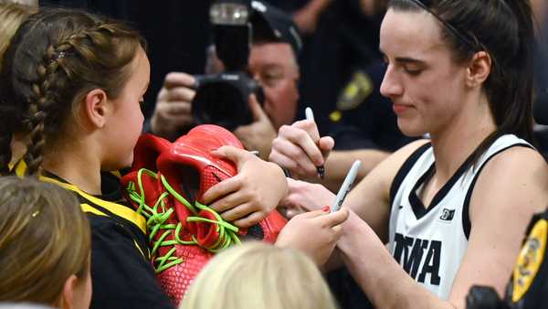 IOWA CITY, IA - DECEMBER 21: A young fan clutches a pair of autographed shoes given to her by Iowa guard Caitlin Clark (22) after a women's college basketball game between the Loyola Chicago Ramblers and the Iowa Hawkeyes on December 21, 2023, at Carver-Hawkeye Arena in Iowa City, IA. (Photo by Keith Gillett/Icon Sportswire via Getty Images)