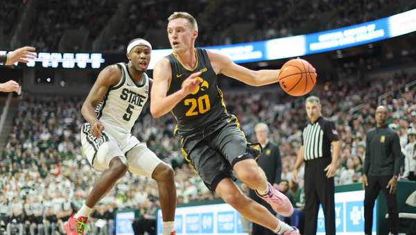 EAST LANSING, MICHIGAN - FEBRUARY 20: Payton Sandfort #20 of the Iowa Hawkeyes drives past Tre Holloman #5 of the Michigan State Spartans during the second half at Breslin Center on February 20, 2024 in East Lansing, Michigan. (Photo by Rey Del Rio/Getty Images)