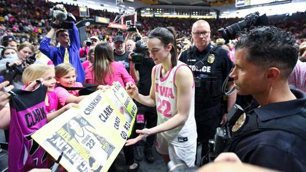 IOWA CITY, IOWA- FEBRUARY 25:  Guard Caitlin Clark #22 of the Iowa Hawkeyes signs autographs as she leaves the court following the match-up against the Illinois Fighting Illini at Carver-Hawkeye Arena on February 25, 2024 in Iowa City, Iowa.  (Photo by Matthew Holst/Getty Images)