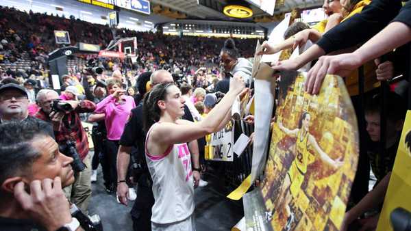 IOWA CITY, IOWA- FEBRUARY 25: Guard Caitlin Clark #22 of the Iowa Hawkeyes signs autographs as she leaves the court following the match-up against the Illinois Fighting Illini at Carver-Hawkeye Arena on February 25, 2024 in Iowa City, Iowa. (Photo by Matthew Holst/Getty Images)