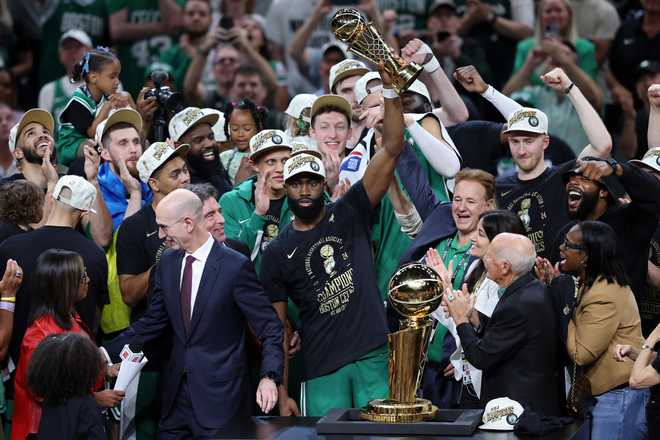Jaylen Brown of the Boston Celtics holds up the Bill Russell Finals MVP trophy after Boston's 106-88 win against the Dallas Mavericks in Game 5 of the 2024 NBA Finals at TD Garden on June 17, 2024 in Boston, Massachusetts.