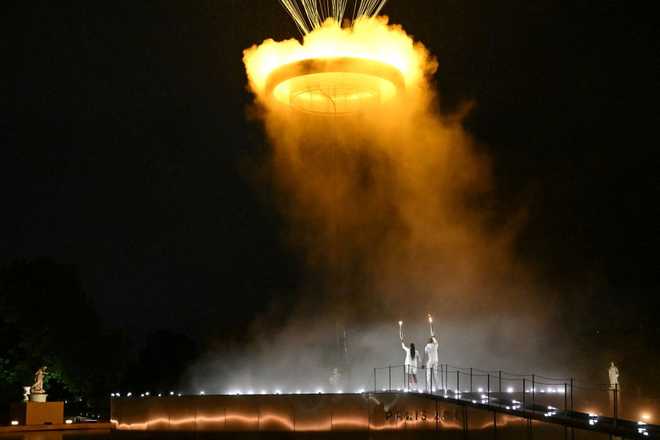 TOPSHOT&#x20;-&#x20;The&#x20;cauldron,&#x20;with&#x20;the&#x20;Olympic&#x20;flame&#x20;lit,&#x20;lifts&#x20;off&#x20;while&#x20;attached&#x20;to&#x20;a&#x20;balloon&#x20;as&#x20;the&#x20;torchbearers&#x20;French&#x20;former&#x20;sprinter&#x20;Marie-Jose&#x20;Perec&#x20;and&#x20;French&#x20;judoka&#x20;Teddy&#x20;Riner&#x20;stand&#x20;in&#x20;front&#x20;during&#x20;the&#x20;opening&#x20;ceremony&#x20;of&#x20;the&#x20;Paris&#x20;2024&#x20;Olympic&#x20;Games&#x20;at&#x20;the&#x20;Jardin&#x20;des&#x20;Tuileries&#x20;&#x28;Tuileries&#x20;Garden&#x29;&#x20;in&#x20;Paris&#x20;on&#x20;July&#x20;26,&#x20;2024.&#x20;&#x28;Photo&#x20;by&#x20;MOHD&#x20;RASFAN&#x20;&#x2F;&#x20;AFP&#x29;&#x20;&#x28;Photo&#x20;by&#x20;MOHD&#x20;RASFAN&#x2F;AFP&#x20;via&#x20;Getty&#x20;Images&#x29;