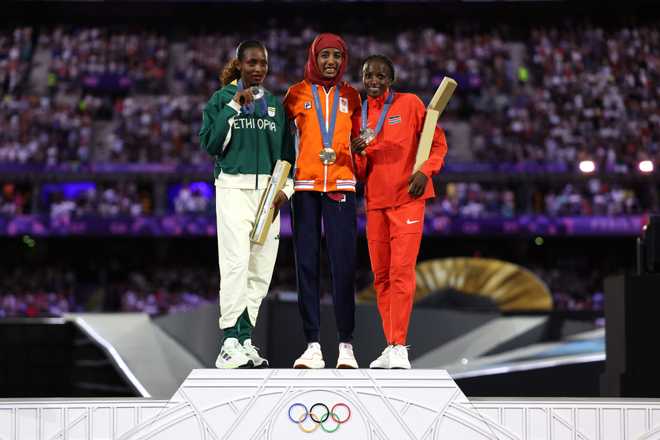 PARIS, FRANCE - AUGUST 11: Gold medalist Sifan Hassan of Team Netherlands (C), Silver medalist Tigst Assefa of Team Ethiopia (L) and Bronze medalist Hellen Obiri of Team Kenya (R) pose on the podium during the Women&apos;s Marathon Medal ceremony during the Closing Ceremony of the Olympic Games Paris 2024 at Stade de France on August 11, 2024 in Paris, France. (Photo by Jamie Squire/Getty Images)