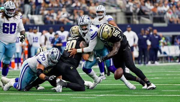 Dallas Cowboys quarterback Dak Prescott (4) fumbles the football after being tackled by New Orleans Saints defensive tackle Bryan Bresee (90) and defensive end Carl Granderson (96) during the game between the Dallas Cowboys and the New Orleans Saints on September 15, 2024 at AT&T Stadium in Arlington, Texas.