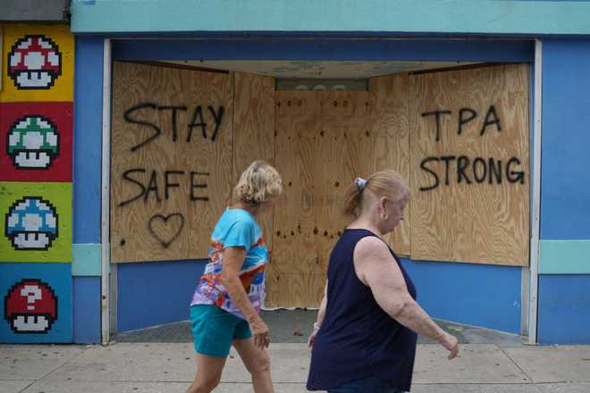 La gente pasa por tiendas en Tampa, Florida, el 8 de octubre de 2024, antes de la llegada del huracán Milton a finales de esta semana.