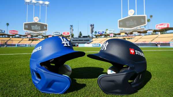 A detail shot of batting helmets for the Los Angeles Dodgers and New York Yankees on the field during the workout day before the 2024 World Series at Dodger Stadium on Thursday, October 24, 2024 in Los Angeles