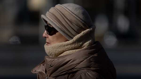 MADRID, SPAIN - DECEMBER 09: A woman wearing a scarf and hat walks through the city on December 9, 2024, in Madrid, Spain.  According to the predictions of the State Meteorological Agency (Aemet) the arrival of a mass of very cold air to the peninsula has left a very cold environment throughout the country. Specifically in the Community of Madrid maximum temperatures are expected to be around 10ºC and a snow level of 1,000 meters above sea level. (Photo By Eduardo Parra/Europa Press via Getty Images)