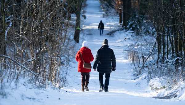 26 December 2024, Saxony, Altenberg: Walkers stroll along a snow-covered hiking trail. Photo: Sebastian Kahnert/dpa (Photo by Sebastian Kahnert/picture alliance via Getty Images)