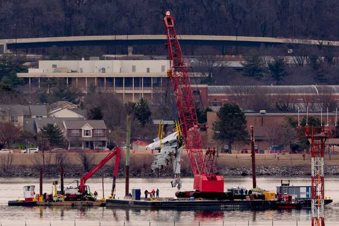 A large portion of the damaged plane fuselage is lifted from the Potomac River during recovery efforts after the American Airlines crash on February 03, 2025 in Arlington, Virginia.