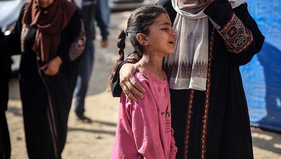 A Palestinian woman and child mourn relatives killed while attempting to get aid at a distribution point near the Israeli-controlled Zikim border crossing, during a funeral service at Al-Shifa hospital in Gaza City, on June 24, 2025.