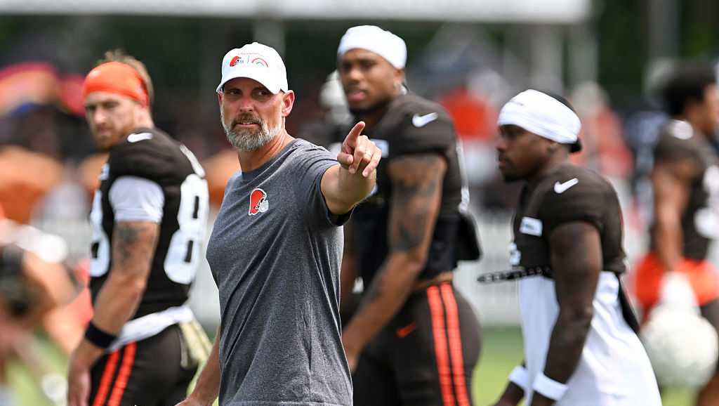 Chad O'Shea coaching during a football practice session, directing players with a focused expression.