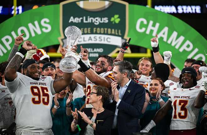 Dublin&#x20;,&#x20;Ireland&#x20;-&#x20;23&#x20;August&#x20;2025&#x3B;&#x20;Iowa&#x20;State&#x20;Cyclones&#x20;defensive&#x20;lineman&#x20;Domonique&#x20;Orange&#x20;&#x23;95,&#x20;left,&#x20;celebrates&#x20;with&#x20;the&#x20;Keough-Naughton&#x20;College&#x20;Football&#x20;Ireland&#x20;trophy,&#x20;alongside&#x20;Aer&#x20;Lingus&#x20;chief&#x20;executive&#x20;officer&#x20;Lynne&#x20;Embleton,&#x20;centre,&#x20;and&#x20;Tanaiste&#x20;Simon&#x20;Harris&#x20;TD,&#x20;after&#x20;his&#x20;side&amp;apos&#x3B;s&#x20;victory&#x20;in&#x20;the&#x20;2025&#x20;Aer&#x20;Lingus&#x20;College&#x20;Football&#x20;Classic&#x20;match&#x20;between&#x20;Kansas&#x20;State&#x20;University&#x20;and&#x20;Iowa&#x20;State&#x20;University&#x20;at&#x20;the&#x20;Aviva&#x20;Stadium&#x20;in&#x20;Dublin.&#x20;&#x28;Photo&#x20;By&#x20;Brendan&#x20;Moran&#x2F;Sportsfile&#x20;via&#x20;Getty&#x20;Images&#x29;
