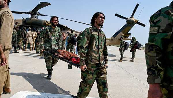 Taliban security personnel carry an earthquake victim evacuated by a military helicopter from the Nurgal district of Kunar province, after her arrival for medical assistance in Jalalabad on September 1, 2025.