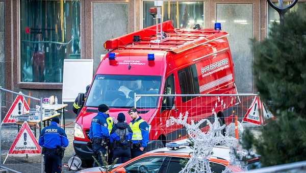 Police officers and rescuers stand next to a firefighters vehicle on the site of a fire that ripped through the bar Le Constellation in Crans-Montana on January 1, 2026.