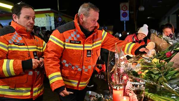 CRANS-MONTANA, SWITZERLAND - JANUARY 01: Firefighters  gather to leave flowers and candles at the scene after a fire broke out overnight at Le Constellation bar on January 01, 2026 in Crans-Montana, Switzerland. According to authorities, the fire began around 1:30 AM local time, with reports that 47 people are believed to have died and over a hundred more seriously injured. (Photo by Harold Cunningham/Getty Images)