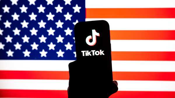 ANKARA, TURKIYE - JANUARY 6: In this photo illustration, US flag is being displayed on a mobile phone screen in front of a computer screen displaying TikTok logo in Ankara, Turkiye on January 6, 2026. (Photo by Ismail Aslandag/Anadolu via Getty Images)