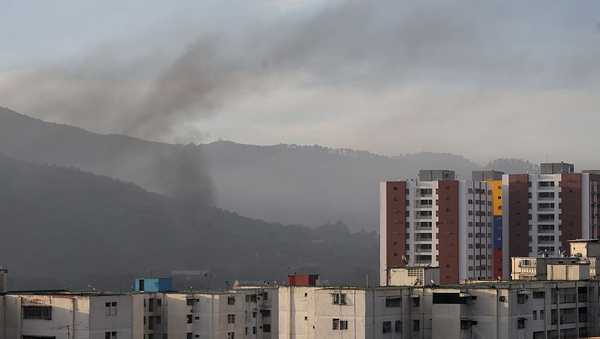 Smoke is seen over buildings after explosions and low-flying aircraft were heard on January 03, 2026 in Caracas, Venezuela.