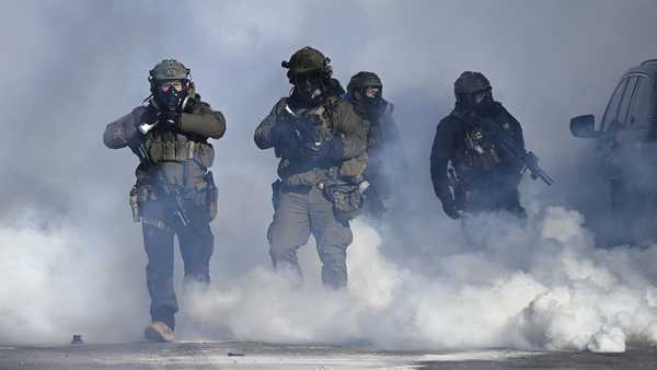 Federal agents point weapons amid tear gas fired at protestors. Earlier, agents shot and killed a man amid a scuffle to arrest him on January 24, 2026, in Minneapolis, Minnesota.