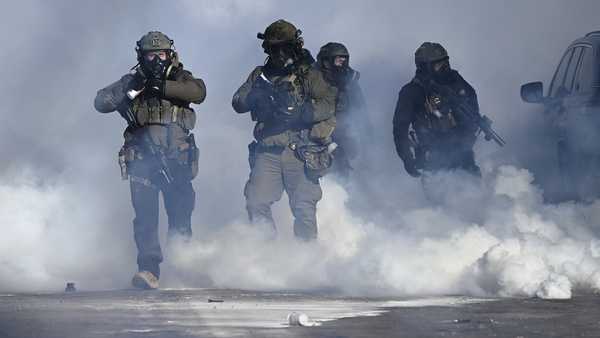 Federal agents point weapons amid tear gas fired at protestors. Earlier, agents shot and killed a man amid a scuffle to arrest him on January 24, 2026, in Minneapolis, Minnesota.