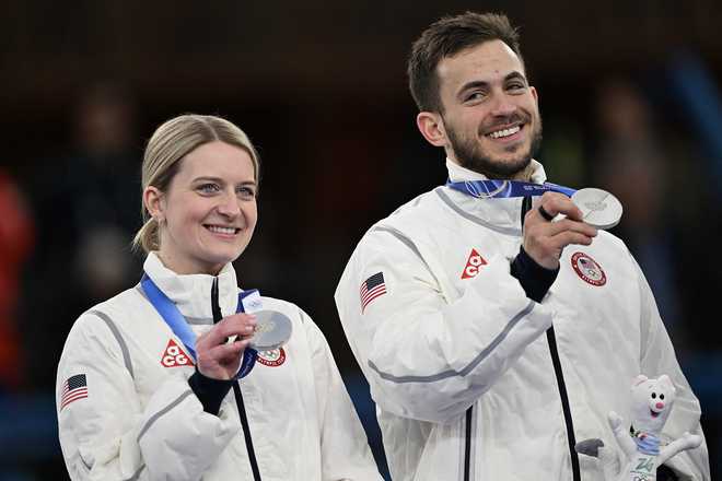 USA's silver medalists Cory Thiesse and Korey Dropkin hold up their medals on the podium of the curling mixed doubles event during the Milan Cortina 2026 Winter Olympic Games at the Cortina Curling Olympic Stadium in Cortina d'Ampezzo on February 10, 2026. (Photo by François-Xavier MARIT / AFP via Getty Images)