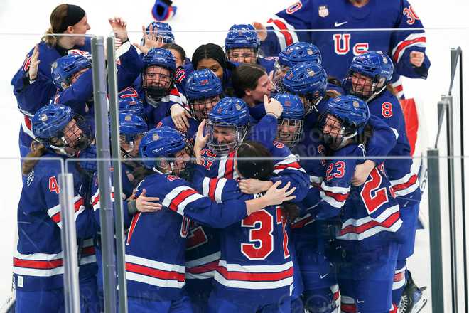 Players of Team United States celebrate winning the gold medal in overtime during the Women's Gold Medal match between the United States and Canada on day 13 of the Milano Cortina 2026 Winter Olympic Games at Milano Santagiulia Ice Hockey Arena on Feb. 19, 2026, in Milan, Italy.