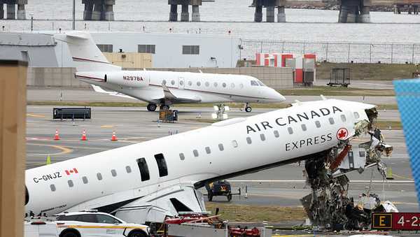 An executive jet taxis behind the Air Canada Express CRJ-900 that collided with a Port Authority fire truck at LaGuardia Airport in New York, after the airport resumed operations on March 23, 2026.