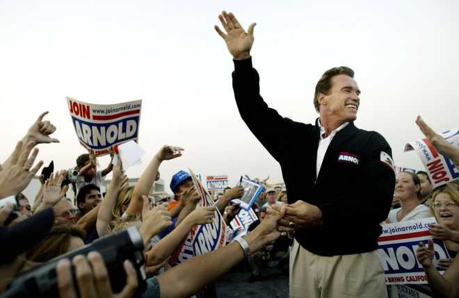 San Bernardino, CA - 6 de outubro: O candidato governamental republicano Arnold Schwarzenegger cumprimenta os apoiadores durante um rali em 6 de outubro de 2003 em San Bernardino, Califórnia. Com um dia restante antes da eleição de 7 de outubro do governador Gray Davis, Schwarzenegger embarcou em uma volta de um dia pela Califórnia. (Foto de Robert Galbraith-Pool/Getty Images)