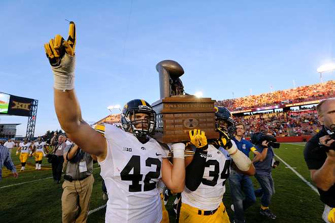 AMES,&#x20;IA&#x20;-&#x20;SEPTEMBER&#x20;12&#x3A;&#x20;&#x20;Fullback&#x20;Macon&#x20;Plewa&#x20;&#x23;42&#x20;and&#x20;defensive&#x20;end&#x20;Nate&#x20;Meier&#x20;&#x23;34&#x20;of&#x20;the&#x20;Iowa&#x20;Hawkeyes&#x20;carry&#x20;the&#x20;Cy-Hawk&#x20;Trophy&#x20;to&#x20;fans&#x20;after&#x20;defeating&#x20;the&#x20;Iowa&#x20;State&#x20;Cyclones&#x20;31-17&#x20;at&#x20;Jack&#x20;Trice&#x20;Stadium&#x20;on&#x20;September&#x20;12,&#x20;2015&#x20;in&#x20;Ames,&#x20;Iowa.&#x20;The&#x20;Iowa&#x20;Hawkeyes&#x20;defeated&#x20;the&#x20;Iowa&#x20;State&#x20;Cyclones&#x20;31-17.&#x20;&#x28;Photo&#x20;by&#x20;David&#x20;Purdy&#x2F;Getty&#x20;Images&#x29;