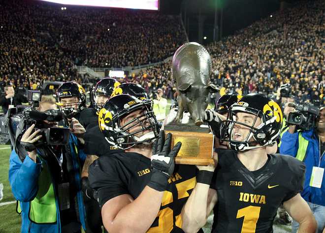 IOWA&#x20;CITY,&#x20;IA&#x20;-&#x20;NOVEMBER&#x20;14&#x3A;&#x20;Offensive&#x20;lineman&#x20;Austin&#x20;Blythe&#x20;&#x23;63&#x20;and&#x20;kicker&#x20;Marshall&#x20;Koehn&#x20;&#x23;1&#x20;of&#x20;the&#x20;Iowa&#x20;Hawkeyes&#x20;carry&#x20;The&#x20;Floyd&#x20;of&#x20;Rosedale&#x20;trophy&#x20;off&#x20;the&#x20;field&#x20;after&#x20;defeating&#x20;the&#x20;Minnesota&#x20;Gophers&#x20;on&#x20;November&#x20;14,&#x20;2015&#x20;at&#x20;Kinnick&#x20;Stadium,&#x20;in&#x20;Iowa&#x20;City,&#x20;Iowa.&#x20;&#x28;Photo&#x20;by&#x20;Matthew&#x20;Holst&#x2F;Getty&#x20;Images&#x29;