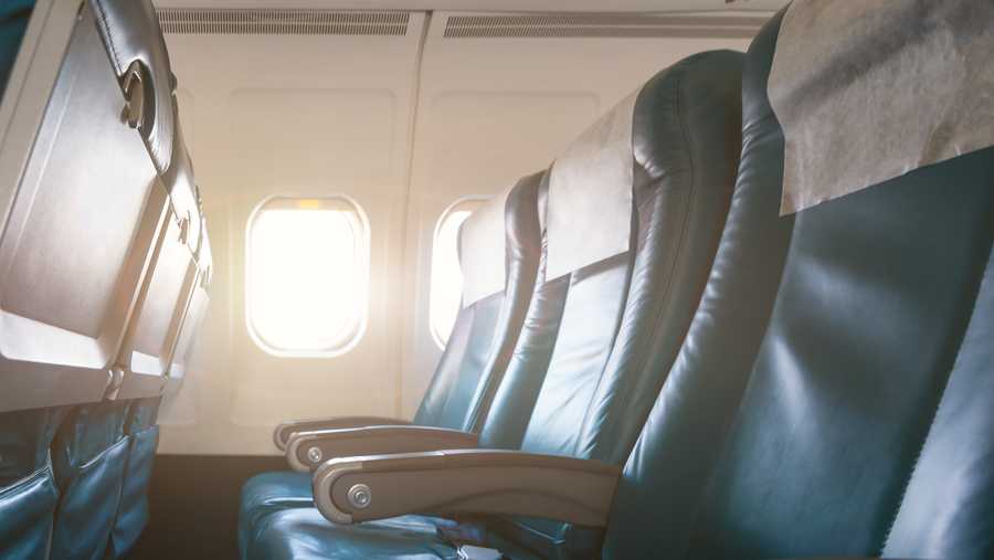 Interior of airplane with empty seats and sunlight at the