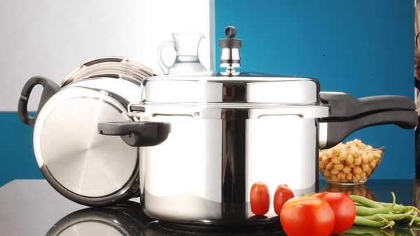 Image of pressure cooker in kitchen with vegetables.