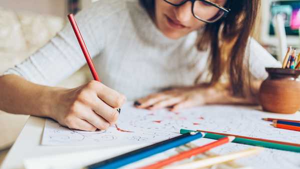 Woman coloring doodle with color pencils for relaxation.