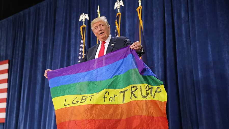 Donald Trump holds an LGBT rainbow flag given to him by supporter Max Nowak during a campaign rally at the Bank of Colorado Arena on the campus of University of Northern Colorado on Oct. 30, 2016, in Greeley, Colorado.