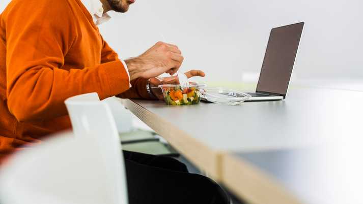 Man having a salad at desk in office