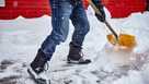 Man shovelling snow from pathway, low section