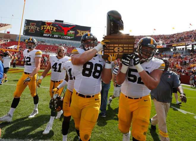AMES,&#x20;IA&#x20;-&#x20;SEPTEMBER&#x20;9&#x3A;&#x20;Defensive&#x20;lineman&#x20;Jake&#x20;Hulett&#x20;&#x23;88&#x20;of&#x20;the&#x20;Iowa&#x20;Hawkeyes,&#x20;and&#x20;offensive&#x20;lineman&#x20;Boone&#x20;Myers&#x20;&#x23;52&#x20;of&#x20;the&#x20;Iowa&#x20;Hawkeyes&#x20;celebrate&#x20;with&#x20;teammates&#x20;by&#x20;carrying&#x20;the&#x20;Cy-Hawk&#x20;Trophy&#x20;off&#x20;the&#x20;field&#x20;after&#x20;defeating&#x20;the&#x20;Iowa&#x20;State&#x20;Cyclones&#x20;44-41&#x20;in&#x20;overtime&#x20;at&#x20;Jack&#x20;Trice&#x20;Stadium&#x20;on&#x20;September&#x20;9,&#x20;2017&#x20;in&#x20;Ames,&#x20;Iowa.&#x20;The&#x20;Iowa&#x20;Hawkeyes&#x20;won&#x20;44-41&#x20;over&#x20;the&#x20;Iowa&#x20;State&#x20;Cyclones.&#x20;&#x28;Photo&#x20;by&#x20;David&#x20;Purdy&#x2F;Getty&#x20;Images&#x29;