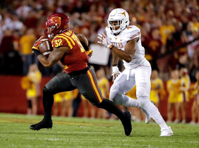 AMES,&#x20;IA&#x20;-&#x20;SEPTEMBER&#x20;28&#x3A;&#x20;Running&#x20;back&#x20;David&#x20;Montgomery&#x20;&#x23;32&#x20;of&#x20;the&#x20;Iowa&#x20;State&#x20;Cyclones&#x20;rushes&#x20;for&#x20;yards&#x20;as&#x20;defensive&#x20;back&#x20;DeShon&#x20;Elliott&#x20;&#x23;4&#x20;of&#x20;the&#x20;Texas&#x20;Longhorns&#x20;defends&#x20;in&#x20;the&#x20;first&#x20;half&#x20;of&#x20;play&#x20;at&#x20;Jack&#x20;Trice&#x20;Stadium&#x20;on&#x20;September&#x20;28,&#x20;2017&#x20;in&#x20;Ames,&#x20;Iowa.&#x20;&#x20;The&#x20;Texas&#x20;Longhorns&#x20;won&#x20;17-7&#x20;over&#x20;the&#x20;Iowa&#x20;State&#x20;Cyclones.&#x20;&#x28;Photo&#x20;by&#x20;David&#x20;K&#x20;Purdy&#x2F;Getty&#x20;Images&#x29;