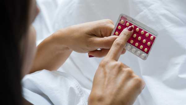 woman holding birth control pills