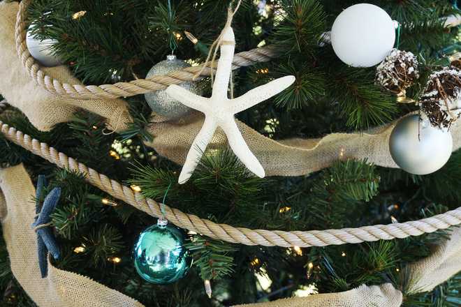 Closeup of a beige, white and light blue decorated nautical themed Christmas tree
