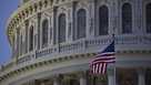 The American flag flies outside the U.S. Capitol before sunrise in Washington, D.C.