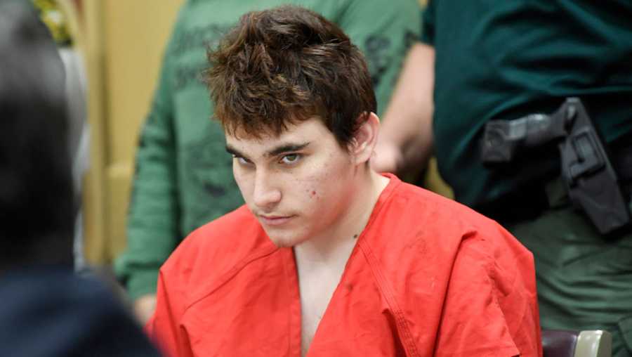 Florida school shooting suspect Nikolas Cruz quickly glances up at the prosecutors while in court before Circuit Judge Elizabeth Scherer for a hearing to move forward the death penalty case Friday afternoon, April 27, 2018, in Fort Lauderdale, Fla.