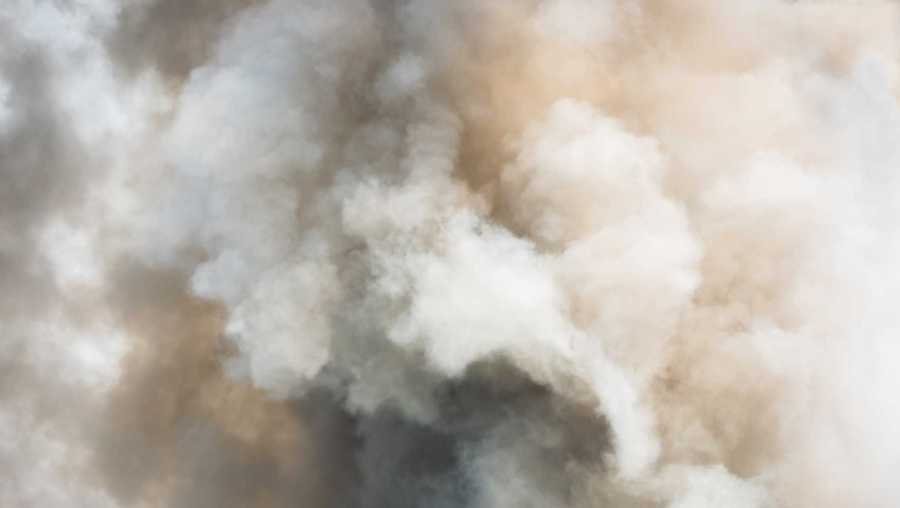 Dense white smoke rises from fire.
