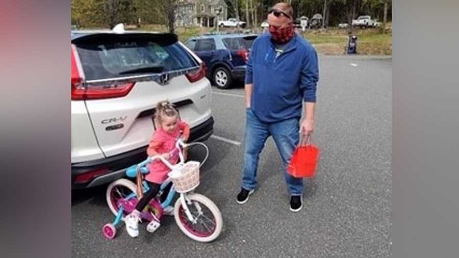 a young girl received a new bike from trooper jim burke of the massachusetts state police after hers was stolen from the houghton's pond area in milton