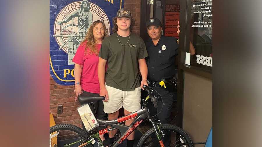Gloucester Police Officer George Carr, right, helped raise the money to get a new bicycle for 15-year-old Jaxson Shaffer, center, who had his bike stolen the week prior.
