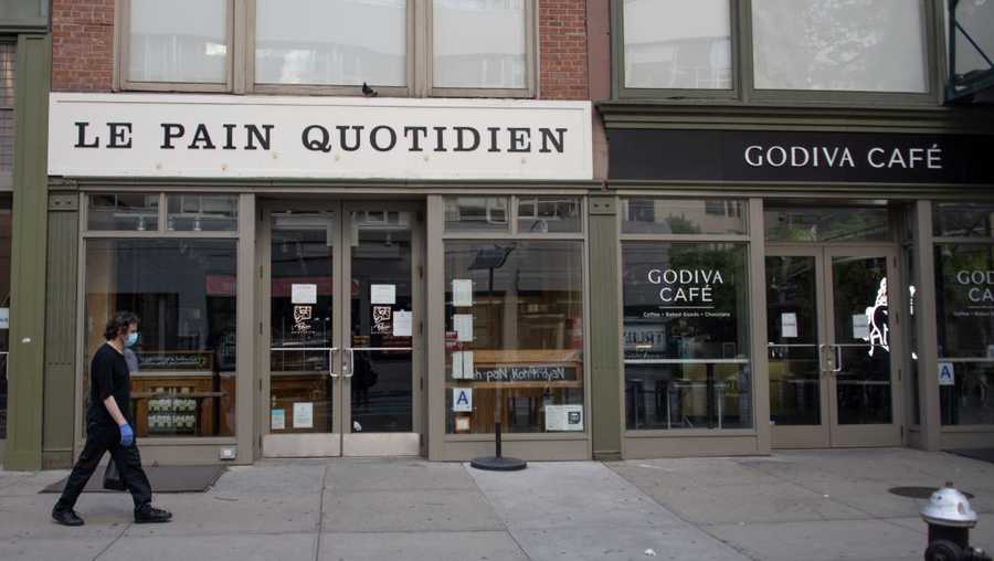 A person wearing a mask walks past a closed Le Pain Quotidien and Godiva cafe on June 24, 2020 in New York City as the city moved into Phase 2 of re-opening following restrictions imposed to curb the coronavirus pandemic. (Photo by Alexi Rosenfeld/Getty Images)