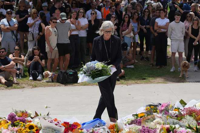 Governor General Sam Mostyn places flowers at a tribute to shooting victims outside the Bondi Pavilion at Sydney's Bondi Beach, Monday, Dec. 15, 2025, a day after a shooting.